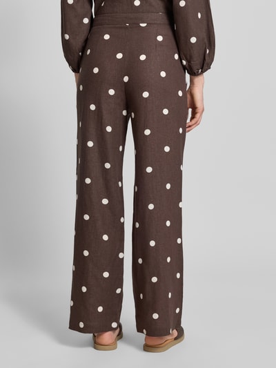 Frauenmodel trägt Stoffhose mit Schleifen-Detail von Jake*s Casual in Braun mit weißen Punkten, Lockerer-Schnitt, Ganzkörperansicht Rückansicht. Bundweite bei Größe 36: 40 cm, Innenbeinlänge bei Größe 36: 83 cm.