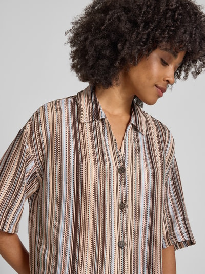 Frauenmodel trägt Boxy Fit Bluse mit V-Ausschnitt von Smith and Soul im Allover-Look, Material-Mix mit Stretch-Anteil, Nahaufnahme Oberkörper.