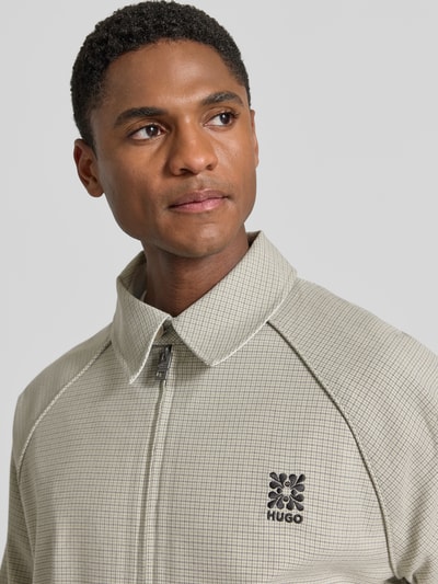 Männermodel trägt Regular Fit Blouson mit Logo-Detail Modell 'Bartos' von HUGO, Optik:Allover-Muster, Nahaufnahme Oberkörper.