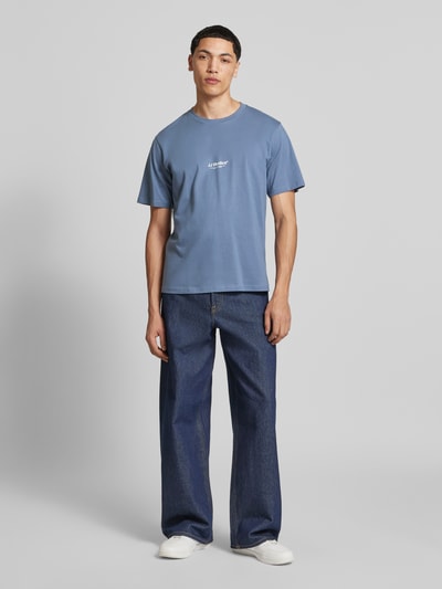 Männermodel trägt T-Shirt mit Logo und Rundhalsausschnitt von Jack & Jones in Blau, Regular Fit, aus Bio-Baumwolle, Ganzkörperansicht von vorne.