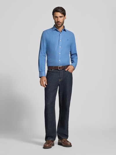 Männermodel trägt Regular Fit Freizeithemd aus Baumwoll-Mix von Polo Ralph Lauren in Hellblau, kombiniert mit Jeans, Ganzkörperansicht von vorne.