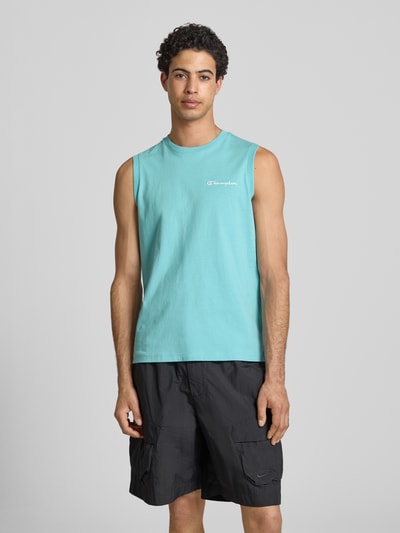 Männermodel trägt Top mit Label-Stitching und Rundhalsausschnitt von CHAMPION in Türkis, reine Baumwolle, Regular Fit, Ganzkörperansicht von vorne.