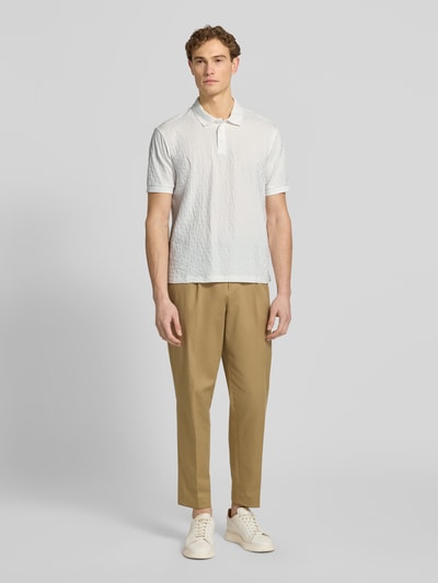 Männermodel trägt Regular Fit Poloshirt mit Strukturmuster von ARMANI EXCHANGE aus Reiner Baumwolle mit Knopfleiste, Ganzkörperansicht von vorne.