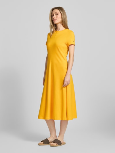 Frauenmodel trägt Midikleid aus reiner Baumwolle von Tommy Hilfiger in Optik: Unifarben, Passform: Regular-Fit, Midi-Länge, Rundhals, Logo-Stitching, Ärmelform: Kurzarm, Materialverarbeitung: Interlock, Ganzkörperansicht von vorne.