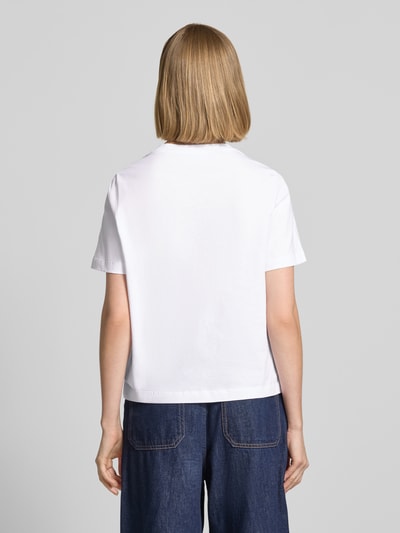 Frauenmodel trägt T-Shirt mit Motiv-Print und Ziersteinbesatz von Rich & Royal aus Reine Baumwolle, Regular-Fit, Rückenlänge 54 cm, Ganzkörperansicht Rückansicht.