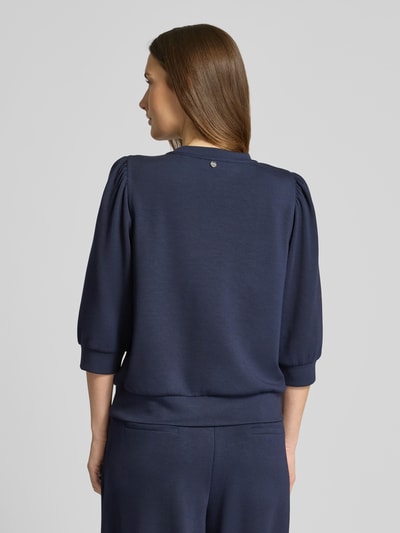 Modelka kobieca ma na sobie Loose Fit Sweatshirt mit 3/4-Arm od Rich & Royal, granatowa kolorystyka, modal z domieszką stretchu, elastyczne wykończenia, balonowe rękawy, stójka, widok sylwetki z tyłu
