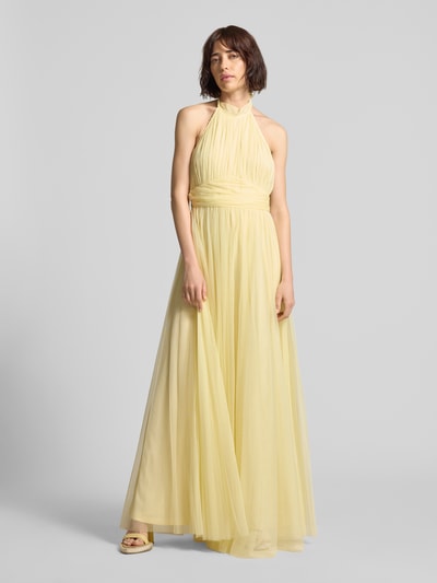 Frauenmodel trägt Neckholder-Cocktailkleid mit Taillenband von LACE & BEADS in zartem Gelb, Mesh, taillierter Schnitt, Maxikleid, Ganzkörperansicht von vorne.