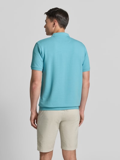 Männermodel trägt Regular Fit Poloshirt aus Baumwoll-Mix von s.Oliver RED LABEL in Hellblau mit Strukturmuster, gerippten Abschlüssen, Ganzkörperansicht Rückansicht.