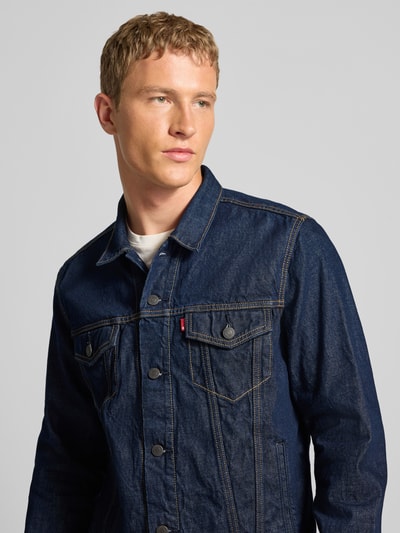 Männermodel trägt Jeansjacke mit Brusttaschen Modell 'THE TRUCKER JACKET' von Levi's®, Reine Baumwolle, Regular-Fit, Nahaufnahme Oberkörper.
