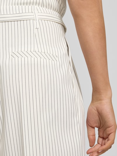 Frauenmodel trägt Loose Fit Weite Hose mit Viskose-Anteil Modell 'HEJULY' von HUGO mit Allover-Streifen, Twill-Textur, Nahaufnahme Oberkörper.