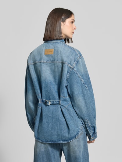 Frauenmodel trägt Oversized Hemdbluse aus reiner Baumwolle Modell 'Sahar' von Samsøe Samsøe in Denim-Optik, Rückansicht, Ganzkörperansicht Rückansicht.