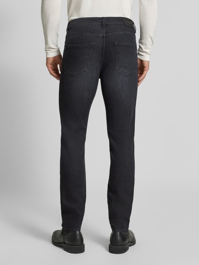 Männermodel trägt Slim Fit Jeans aus Baumwoll-Mix Modell 'Delaware' von BOSS in Dunkelblau, Herren Straight Fit Jeans, Ganzkörperansicht Rückansicht.