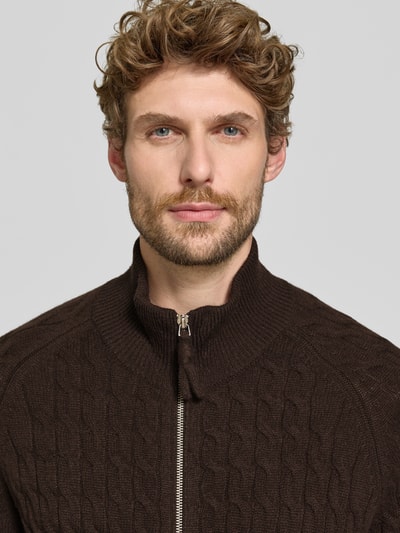 Männermodel trägt Regular Fit Strickjacke aus reinem Kaschmir mit Zopfmuster von FTC Cashmere in Dunkelbraun, Nahaufnahme Oberkörper.