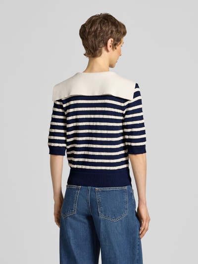 Frauenmodel trägt Cardigan aus Viskose-Mix mit 1/2-Arm von Rich & Royal in Dunkelblau mit weißen Streifen, Rückenansicht, Regular Fit, Umlegekragen, Knopfleiste, Baumwoll-Anteil, strukturierte Stricktextur, Rückenlänge 50 cm, Ärmellänge 30 cm. Ganzkörperansicht Rückansicht.