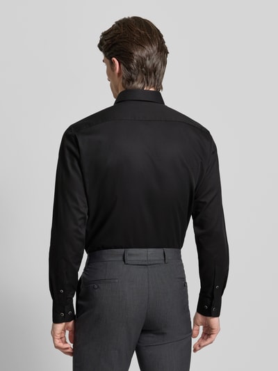 Männermodel trägt Regular Fit Businesshemd aus Baumwolle mit Kentkragen von OLYMP in Schwarz, glatte Struktur, Ganzkörperansicht Rückansicht.
