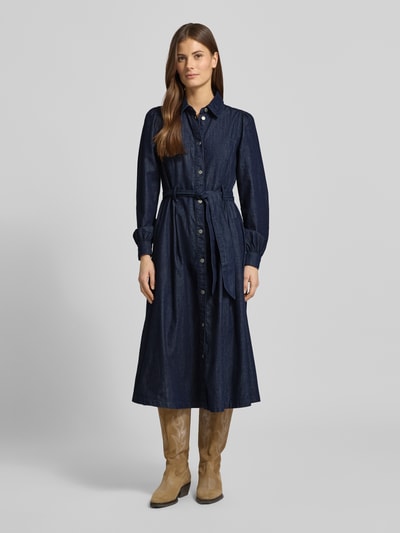 Frauenmodel trägt Midikleid mit Druckknopfleiste von More & More aus dunkelblauer Baumwolle, taillierter Schnitt, Hemdblusenkragen, Taillengürtel, Ganzkörperansicht von vorne.