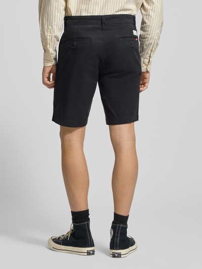 Männermodel trägt Regular Fit Chino Shorts aus Baumwoll-Mix von Levi's®, schwarz, Gesäßtaschen, Knopf- und Reißverschluss, Ganzkörperansicht Rückansicht.