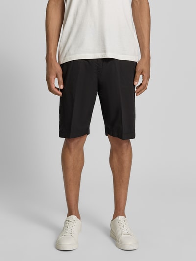 Männermodel trägt Hose mit Gesäßtaschen von MARKUP, schwarze Baumwolle, Regular Fit, sichtbare Gesäßtaschen, Ganzkörperansicht von vorne.