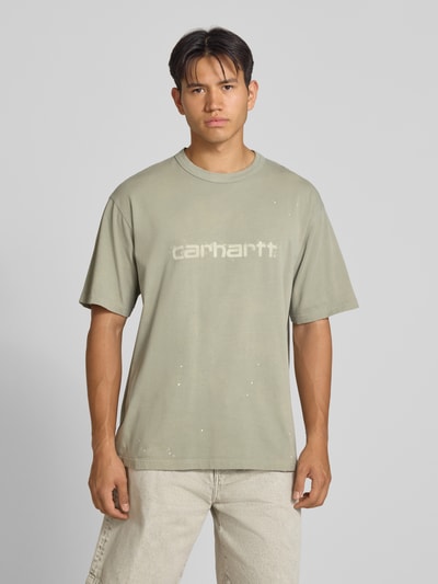 Męski model nosi Regular Fit T-Shirt aus reiner Baumwolle Model 'Painter' von Carhartt Work In Progress, kolor jasnoszary z detalem z logo, bawełna, krój regular fit, długość tyłu w rozmiarze M: 72 cm, Ganzkörperansicht von vorne.