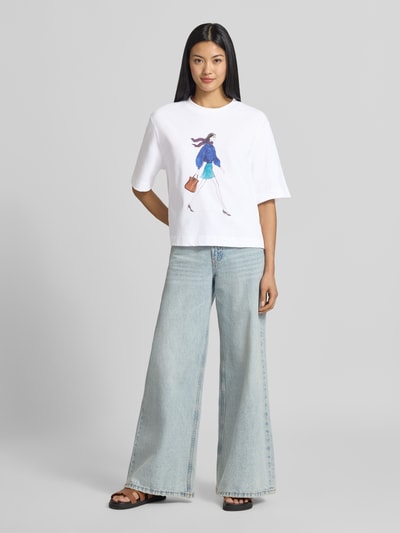 Vrouwenmodel draagt Relaxed Fit T-Shirt aus reiner Baumwolle van Rich & Royal met motiefprint, ronde hals, puur katoen, ruglengte maat S 50 cm, Ganzkörperansicht von vorne.