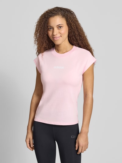Frauenmodel trägt T-Shirt mit Rundhalsausschnitt von adidas Sportswear in Rosa, taillierte Passform, reine Baumwolle, Label-Detail, Ganzkörperansicht von vorne. Rückenlänge bei Größe S: 57 cm.