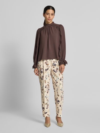 Vrouwenmodel draagt Feminine Fit Hose im Allover-Look van Marc Cain, Materiaalmix met stretch, high waist, bandplooien, all-over look, maat 36 bandwijdte 27 cm, binnenbeenlengte 74 cm, full body frontaal.