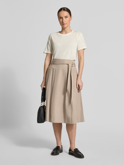 Frauenmodel trägt Regular Fit Midirock in Falten-Optik von Christian Berg Woman aus Reine Baumwolle in Beige, Ganzkörperansicht von vorne. Bundweite 37 cm, Gesamtlänge 74 cm, mit Reißverschluss und abnehmbarem Stoffband.