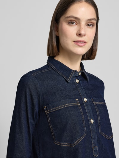 Vrouwenmodel draagt Regular Fit Jeanskleid aus Baumwoll-Mix van Tom Tailor in denimlook met borstzakken en knoopsluiting, katoenmix. Nahaufnahme bovenlichaam.