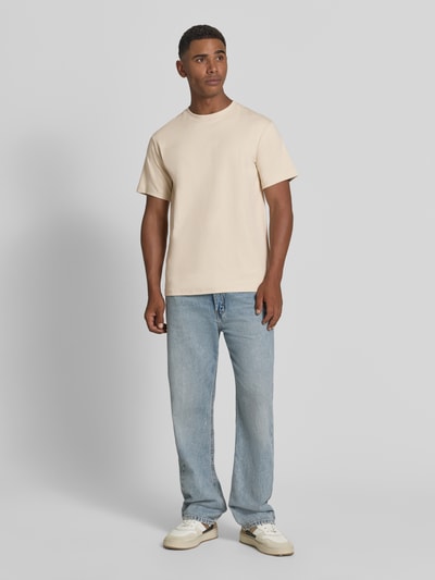 Männermodel trägt Regular Fit T-Shirt aus Baumwoll-Mix Modell 'SPENCER' von Selected Homme in Beige, glatte Textur, Ganzkörperansicht von vorne. Herren T-Shirt von Selected Homme.