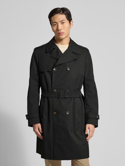Męski model nosi Regular Fit Trenchcoat mit Reverskragen Modell 'Aberdeen' od CINQUE, czarny, z paskiem i podwójnym rzędem guzików, krój regular fit, widok całej sylwetki z przodu. Szerokość w rozmiarze 50: 44 cm, szerokość klatki piersiowej: 45 cm, długość rękawa: 66 cm, długość pleców: 97 cm.