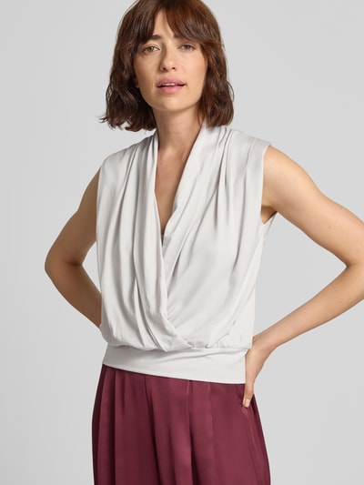 Frauenmodel trägt Top aus Lyocell-Elasthan-Mix mit V-Ausschnitt von windsor., reguläre Passform, helle Farbe, drapierter Stoff, Nahaufnahme Oberkörper.