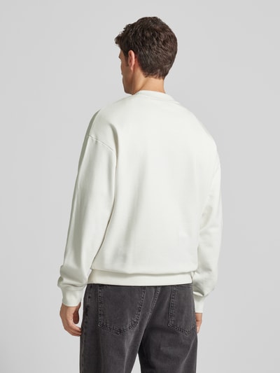 Männermodel trägt Regular Fit Sweatshirt aus reiner Baumwolle Modell 'DAPOCREW' von HUGO in Unifarbe, Rippbündchen, Ganzkörperansicht Rückansicht.