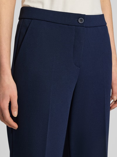 Frauenmodel trägt Hose mit verkürzter Passform Modell 'Hillda-650' von STEHMANN aus dunkelblauem Material-Mix mit Stretch-Anteil, Nahaufnahme Oberkörper, Kontext: Damen Hose, verkürzte Passform, Bügelfalten, Bundweite 37 cm, Innenbeinlänge 65 cm.