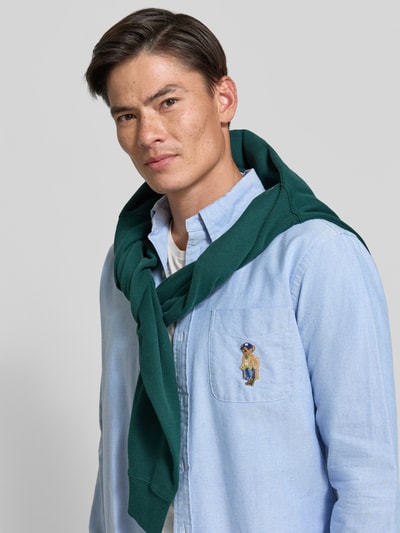 Männermodel trägt Custom Fit Freizeithemd aus reiner Baumwolle von Polo Ralph Lauren in Hellblau, Nahaufnahme Oberkörper.