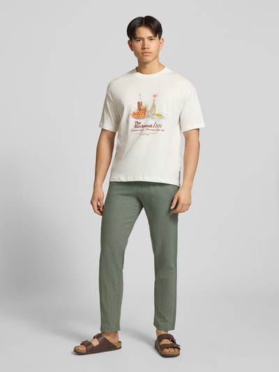 Męski model nosi Hose aus Baumwoll-Leinen-Mix Modell 'KANE' od Jack & Jones, kolor zielony, krój regular fit, elastyczny pas, szerokość w rozmiarze M: 41 cm, długość nogawki od wewnątrz w rozmiarze M: 81 cm, całopostaciowy widok z przodu.