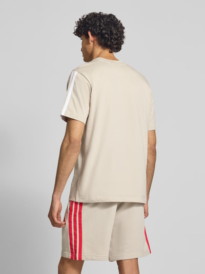 Männermodel trägt Regular Fit T-Shirt aus reiner Baumwolle von adidas Sportswear in Optik: Unifarben mit Logo-Print, Kontraststreifen, Kurzarm, Rundhals-Ausschnitt, in natürlicher Farbgebung, glatte Textur, Ganzkörperansicht Rückansicht.