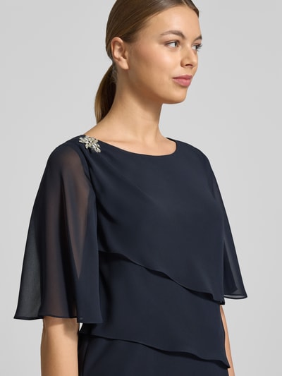 Frauenmodel trägt Relaxed Fit Kleid mit Ziersteinbesatz von Christian Berg Cocktail in Dunkelblau, semitransparent, Nahaufnahme Oberkörper.