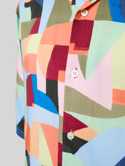 Männermodel trägt Relaxed Fit Freizeithemd aus reiner Viskose von Shiwi, buntes Asymmetrisches-Design, Reverskragen, Kurzärmelig, Nahaufnahme Oberkörper.