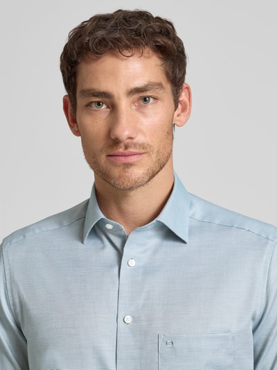 Männermodel trägt Regular Fit Business-Hemd mit Kentkragen von OLYMP, Unifarbenes-Design, Strukturmuster, Reine Baumwolle, Nahaufnahme Oberkörper.