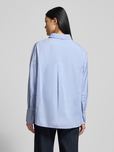 Frauenmodel trägt Regular Fit Hemdbluse aus reiner Baumwolle von Marc O'Polo mit blau-weißem Allover-Streifenmuster, Rückenpasse mit Cacharel-Falte, langarm, Hemdblusenkragen, Ganzkörperansicht Rückansicht