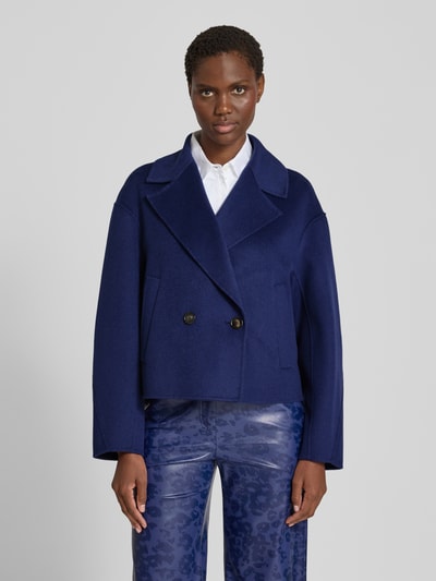 Vrouwenmodel draagt Relaxed Fit Jacke aus reiner Wolle van Marc Cain in diepblauw, zuiver wol, Reverskraag, 2-knoopsluiting, Ruglengte maat 36: 54 cm, Schouderbreedte: 53 cm, Borstwijdte: 56 cm, Mouwlengte: 54 cm, Ganzlichaamsaanzicht van voren