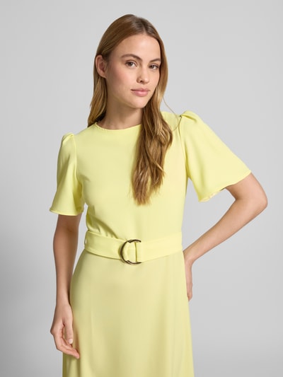 Modelka kobieca nosi 'Cocktailkleid mit Gürtel und Rundhalsausschnitt' od Rinascimento, jasny żółty mieszanka materiałów z dodatkiem streczu, taliowany krój slim fit, sukienka midi z okrągłym dekoltem, zamek błyskawiczny z tyłu, długość tyłu w rozmiarze S: 36 cm, szerokość w rozmiarze S: 40 cm, długość rękawów w rozmiarze S: 28 cm, gładka tekstura, widok całego przodu.