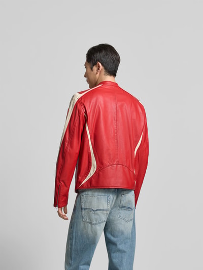 Männermodel trägt Regular Fit Jacke in Leder-Optik von Diesel in Rot mit cremefarbenen Details, Zweiwegereißverschluss, Ganzkörperansicht Rückansicht.