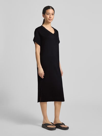 Frauenmodel trägt T-Shirt-Kleid mit V-Ausschnitt von Soyaconcept in Schwarz, gerader Schnitt, Midilänge, Material-Mix, Ganzkörperansicht von vorne.
