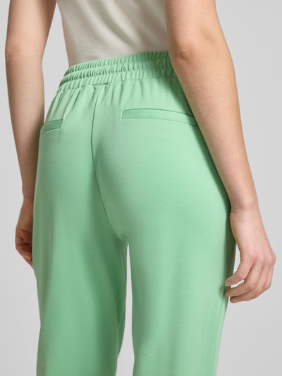 Frauenmodel trägt Hose mit elastischem Bund Modell 'KATE' von ICHI aus grünem Material-Mix mit Viskose-Anteil, Detailaufnahme Rückansicht.