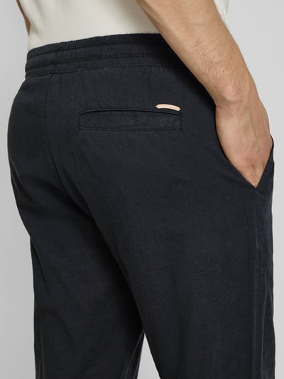 Männermodel trägt Hose aus Baumwoll-Leinen-Mix Modell 'KANE' von Jack & Jones in Dunkelblau, Regular-Fit, Detailaufnahme Rückansicht. Bundweite 41 cm, Innenbeinlänge 81 cm, elastischer Bund.