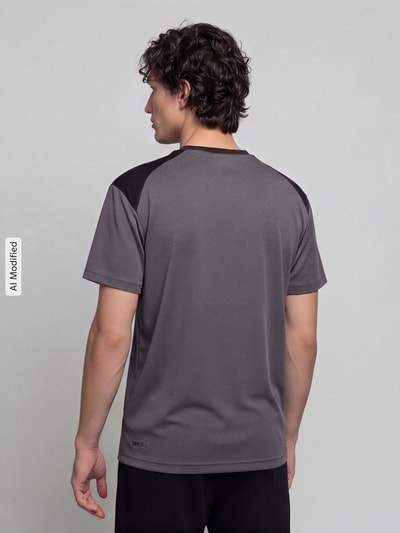 Männermodel trägt graues Regular Fit T-Shirt mit DryCell Technology Modell 'PUMATECH Essentials Tee' von PUMA, Rückansicht, Herren T-Shirt von PUMA Performance.