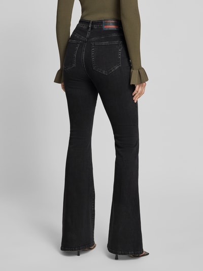 Frauenmodel trägt Flared Fit Jeans mit Logo-Detail von Diesel aus schwarzem Baumwoll-Mix, 5-Pocket-Design, feine Struktur, Ganzkörperansicht Rückansicht.
