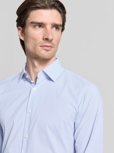 Männermodel trägt Regular Fit Businesshemd mit Kentkragen Modell 'JOE' von BOSS, feine Webstruktur, blau-weiß gestreift, Nahaufnahme Oberkörper.