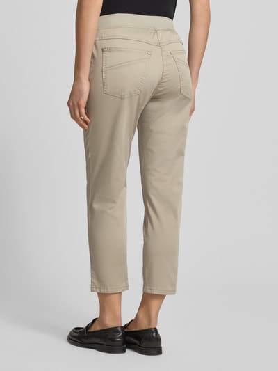 Männermodel trägt Caprihose mit elastischem Bund Modell 'Pamina' von Raphaela By Brax, bawełna i elastan, krój regular fit, szerokość w rozmiarze 36K: 35 cm, długość nogawki wewnętrznej w rozmiarze 36K: 62 cm, beż, tylne kieszenie, gładka tekstura, Ganzkörperansicht Rückansicht.